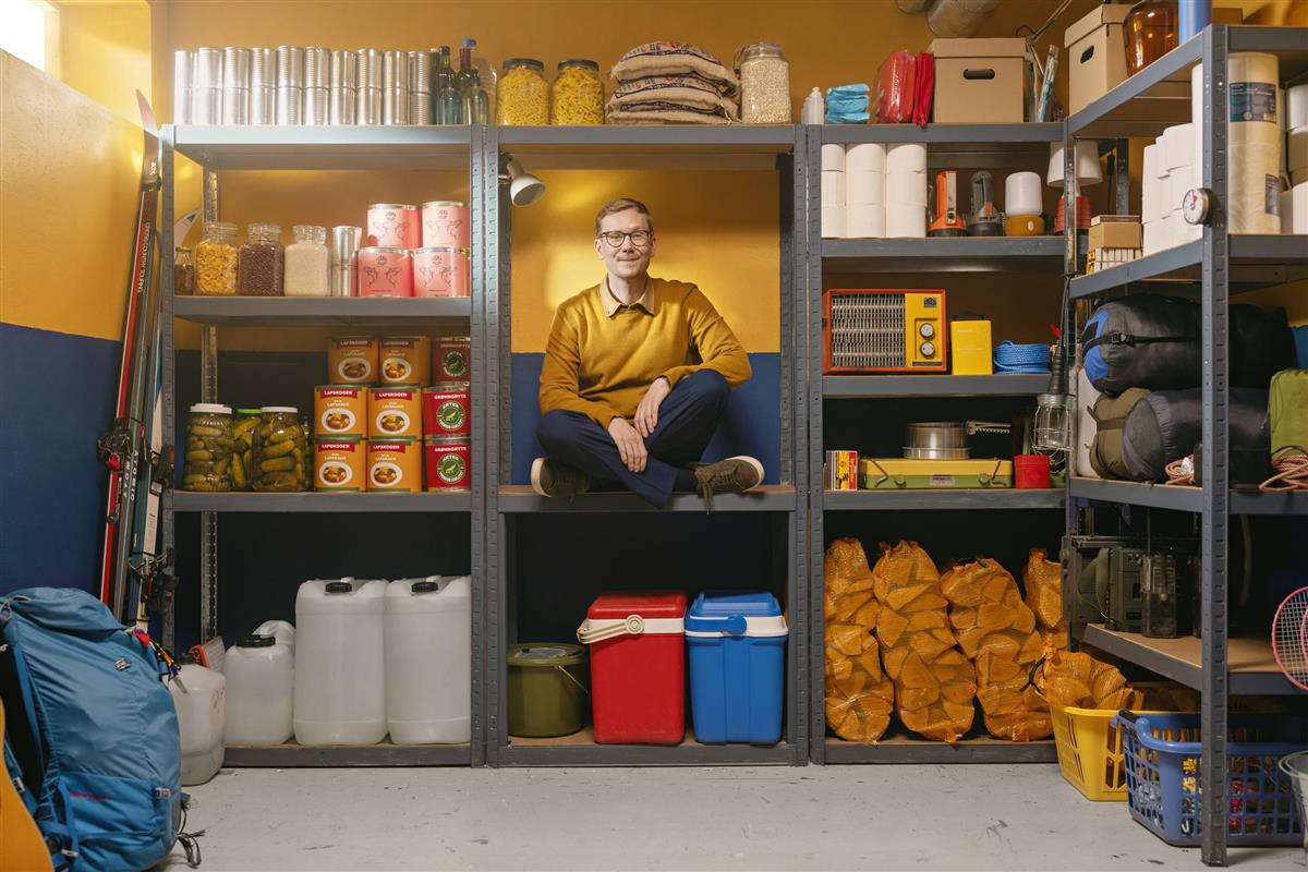 Mann i en hylle med egenberedskapsprodukter - Klikk for stort bilde